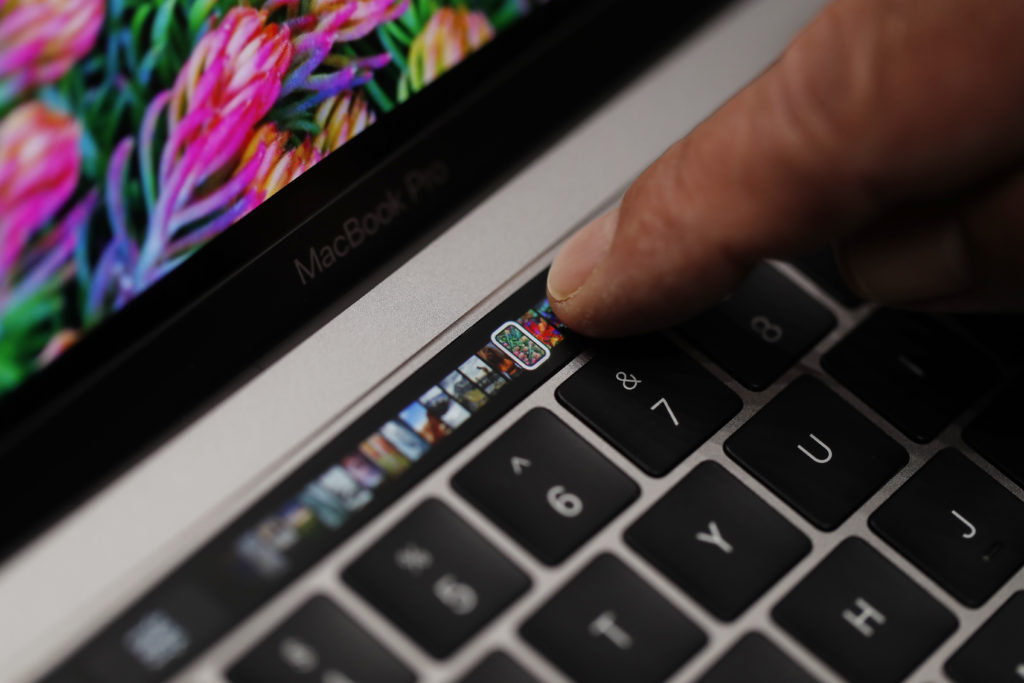 CUPERTINO, CA - OCTOBER 27: An Apple employee points to the Touch Bar on a new Apple MacBook Pro laptop during a product launch event on October 27, 2016 in Cupertino, California. Apple Inc. unveiled the latest iterations of its MacBook Pro line of laptops and TV app. (Photo by Stephen Lam/Getty Images)